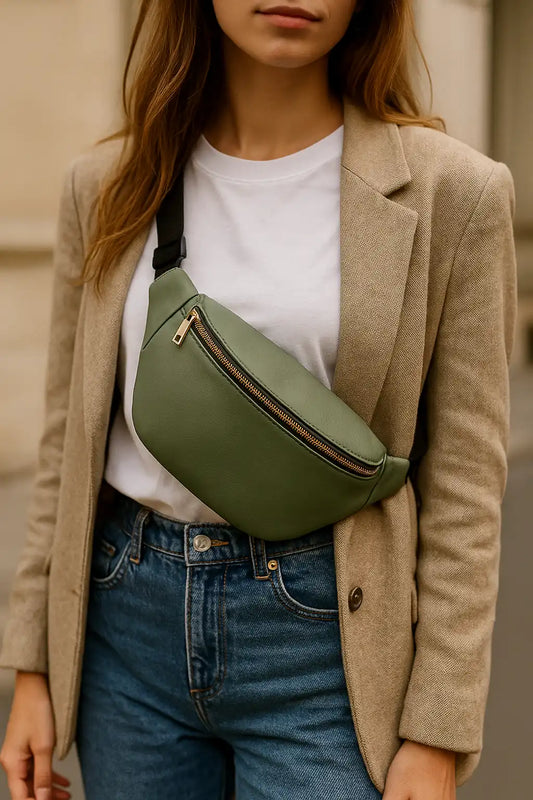 Femme stylée portant un sac banane vert en bandoulière sur une tenue urbaine chic