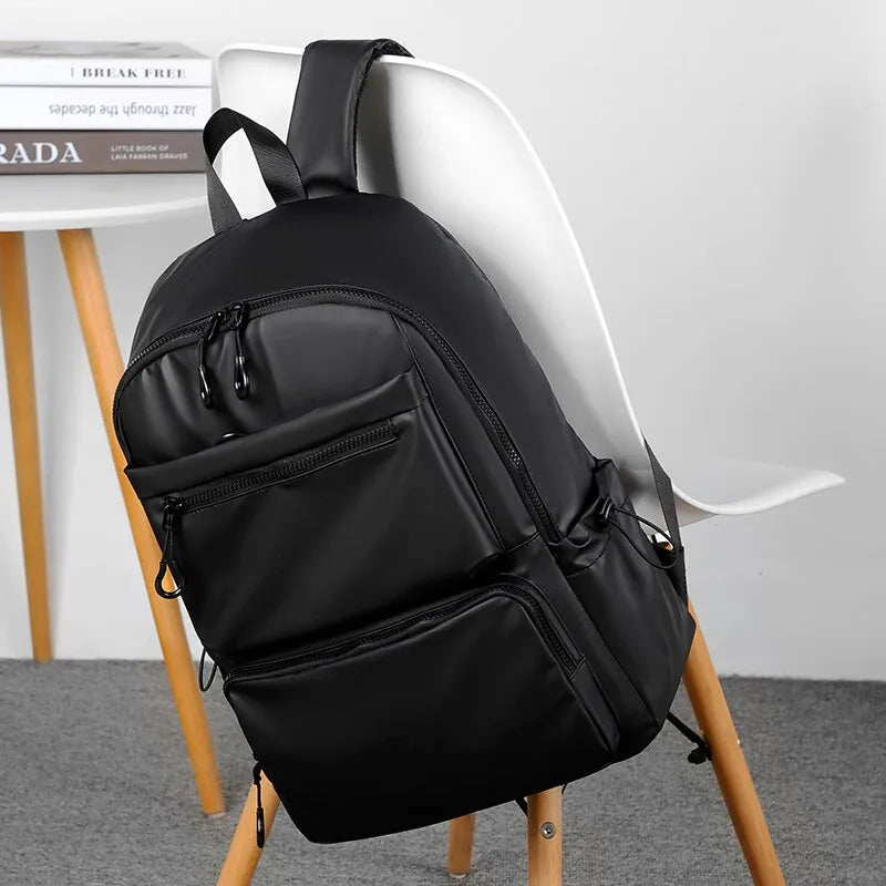 sac à dos multi compartiment homme noir accroché sur une chaise