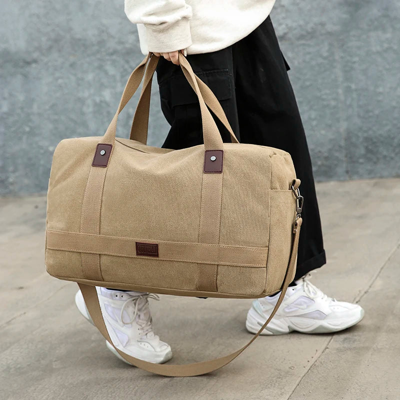 sac voyage toile porté à la main par un mannequin